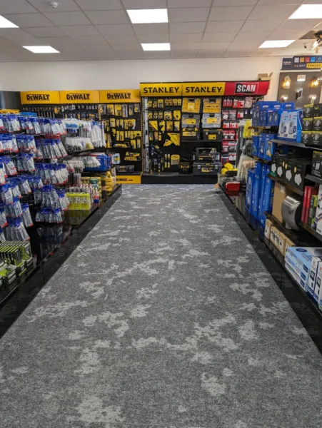 Aisle in the trade counter area with DeWalt and Stanley tool displays and shelves of fixings and accessories